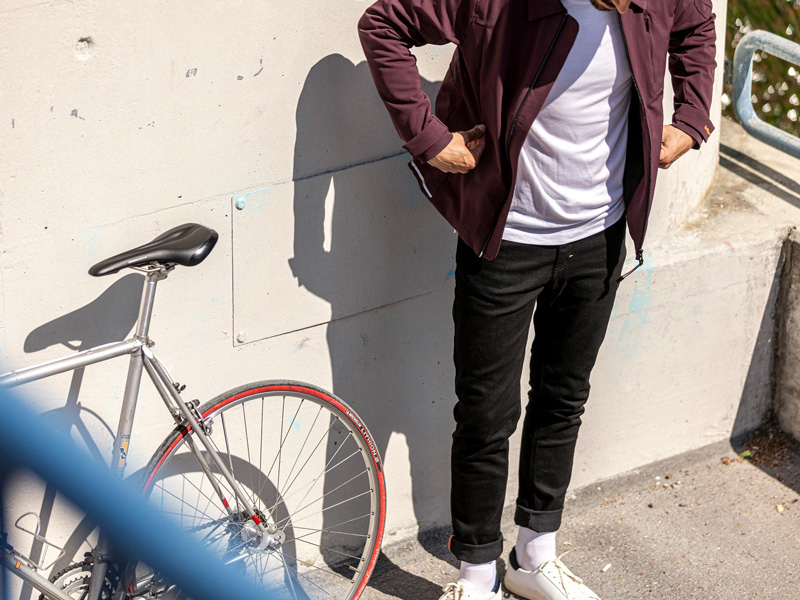 Junger Mann in Le Picot Kleidung neben Fahrrad