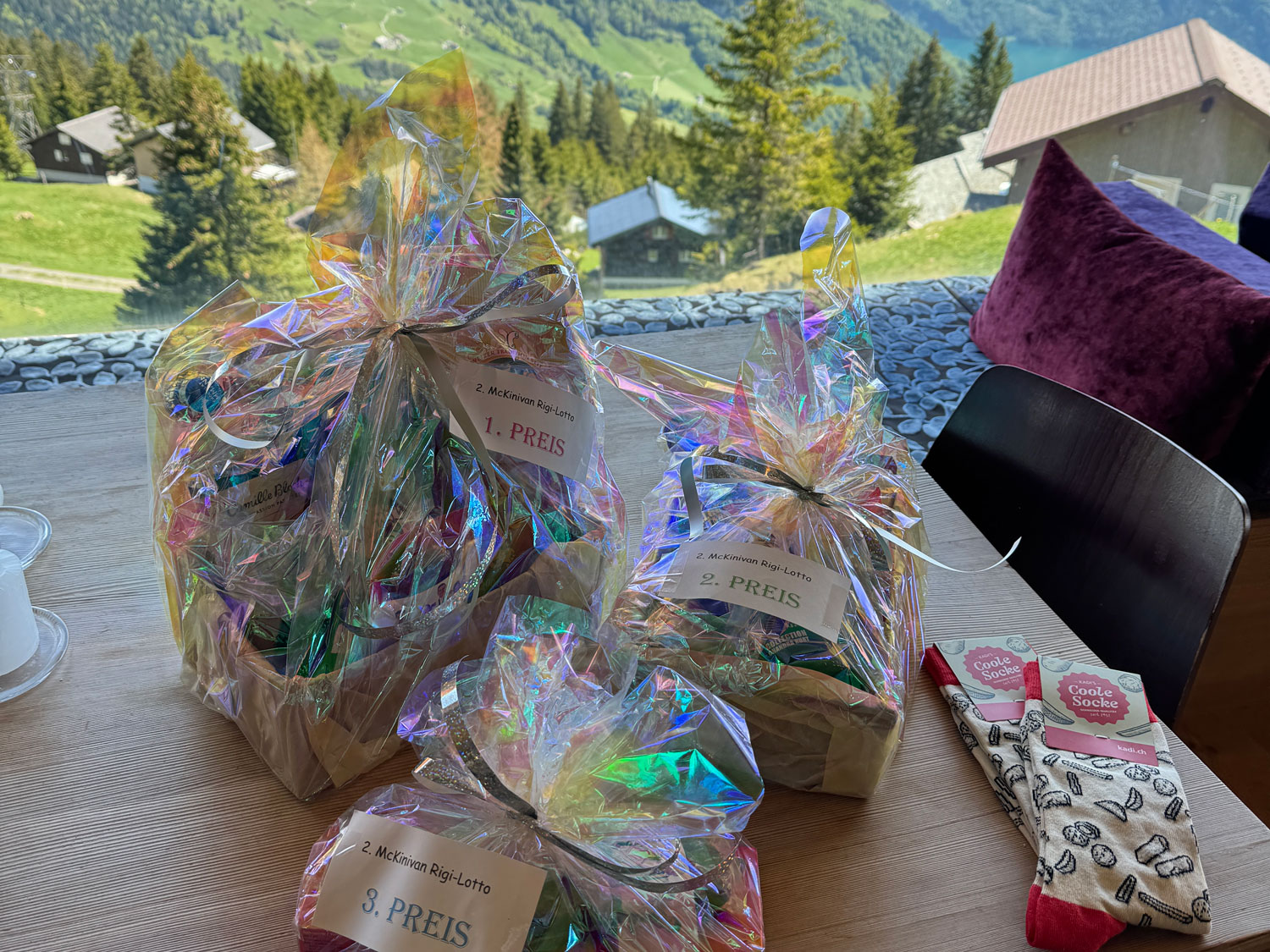 Drei Geschenkkörbe in schimmernder Folie mit Berglandschaft im Hintergrund